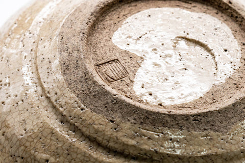 Underside and foot closeup showing the exposed clay base