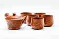 Red shudei Tokoname-yaki tea set with an engraved floral motif: a side-handled teapot and five yunomi cups.