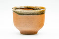 Front view showing the contrast between the orange clay lower body and the brown glazed upper rim.