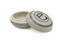 Round pale-glazed ceramic kogo incense container with its lid set ajar, the lid painted in blue with the snake character and a ring border.