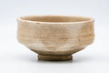 Low, wide milk-white badarai-gata chawan, front view with a finely crazed glaze.
