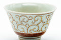 Close-up of one cup showing the red and gold scrolling vine pattern.