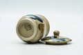 The cup on its side with the lid beside, showing the base.