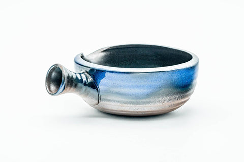 Three-quarter view showing the side handle and layered blue glaze.