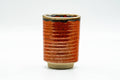 Front view of the orange-red ribbed cup showing its horizontally grooved surface.