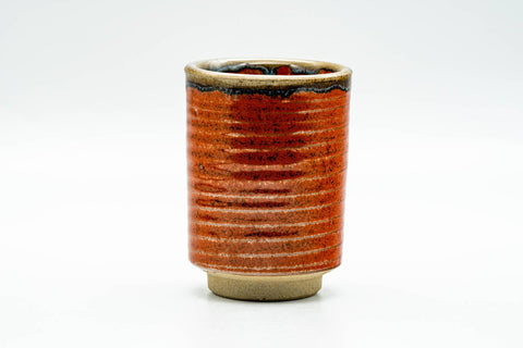 Front view of the orange-red ribbed cup showing its horizontally grooved surface.