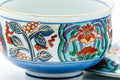 Close-up of the floral band with red, green and gold motifs over a blue ground.