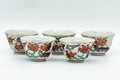 The five matching yunomi teacups arranged in a row, showing their floral exteriors.