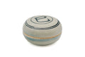 Front view of the closed kogo, its domed lid showing the blue snake character within concentric rings over a celadon-grey body.