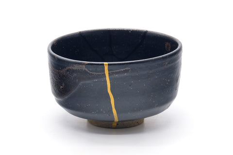 Three-quarter view showing the gold kintsugi seams over the black glaze.