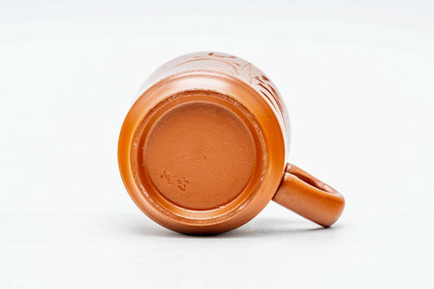 The cup tilted on its side, showing the foot and the handle.