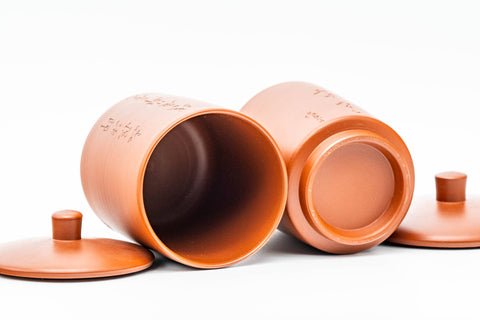 The two cups tipped on their sides with lids beside them, revealing the interiors.