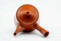 Three-quarter view showing the spout and bamboo handle of the red kyusu.