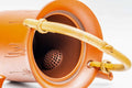 Overhead closeup looking into the dobin's mouth, showing the integrated ceramic filter holes near the spout