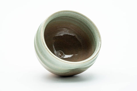 The cup tipped to reveal the glazed interior.