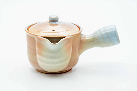Pink-beige drip-glazed Hagi-yaki kyusu, three-quarter view from the rear with the handle to the right