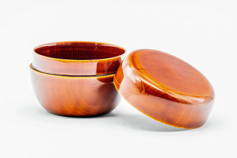 The orange ko-natsume open with the body upright showing its dark interior and the lid lying flat beside it.