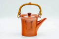 Red shudei Tokoname-yaki top-handled dobin teapot with an arched gold metal handle, three-quarter view with calligraphy engraved on the body