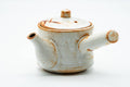 Opposite profile of the teapot showing the spout and cream shino glaze.