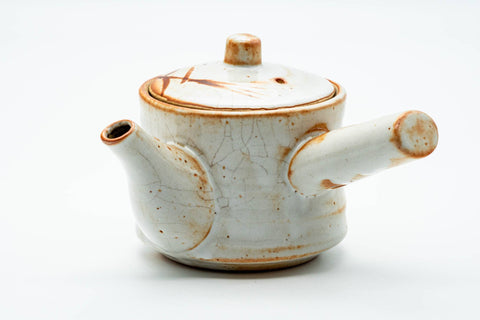 Opposite profile of the teapot showing the spout and cream shino glaze.