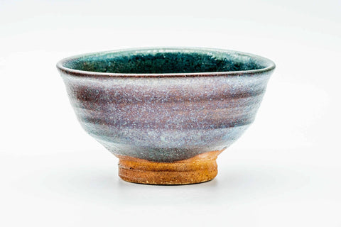 Front view of the chawan, glaze graduating from green-turquoise to earthy brown, resting on a pale foot.