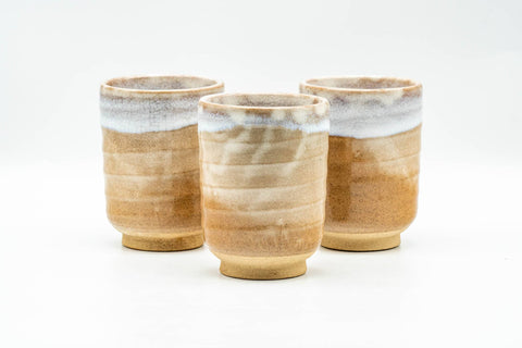 Three Hagi-yaki teacups arranged side by side showing the milky white glaze