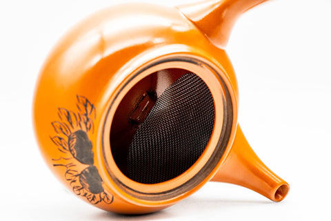 Teapot with the lid removed, showing the built-in ceramic mesh strainer inside the body.