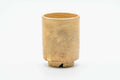 Cylindrical Hagi-yaki teacup with an earthy, textured beige-cream glaze, front view.