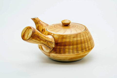 Side view of the kyusu with the handle to the right, lid on, showing the spout.