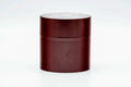 Front view of the closed cylindrical canister in deep maroon