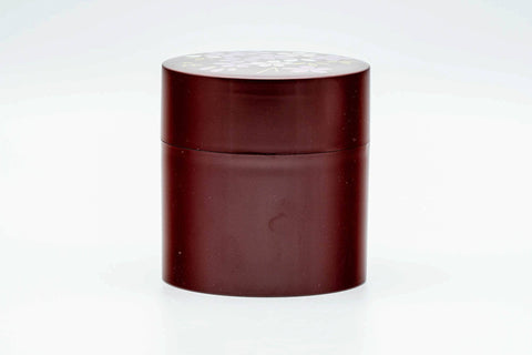 Front view of the closed cylindrical canister in deep maroon