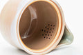 Interior view of the pink-beige Hagi-yaki kyusu showing the perforated do-ake strainer holes inside