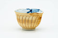 Single yellow Arita-yaki yunomi showing the blue floral pattern glazed inside the cup