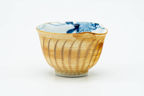 Single yellow Arita-yaki yunomi showing the blue floral pattern glazed inside the cup