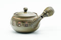 Three-quarter front view of a green-and-brown marbled nerikomi Tokoname-yaki kyusu with carved banding, lid on, side handle right and spout left.