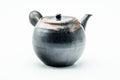 Side profile of the dark teapot, spout to the left and hollow side handle facing the viewer.