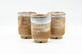 Set of three beige and milky white Hagi-yaki yunomi grouped together, front view