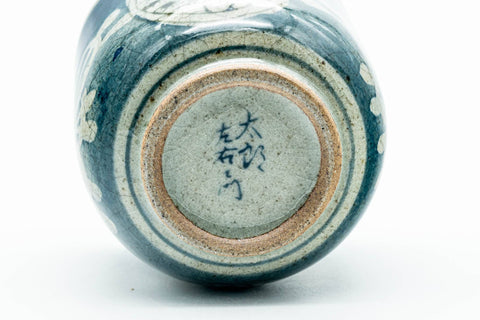 The cup tipped to reveal the foot and maker's stamp.