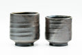 The pair viewed from another side, showing the ribbed darker grey glaze on the lower bodies.
