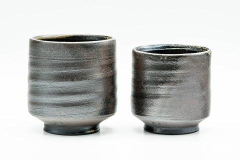 The pair viewed from another side, showing the ribbed darker grey glaze on the lower bodies.