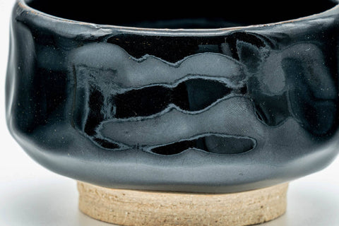 Side view of the black hantsutsu chawan showing the half-cylinder form and glossy glaze