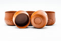 The cups grouped together, one tipped to reveal the dark glazed interior and foot.