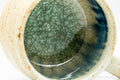 Close-up of the cup's interior showing the textured blue-green glaze pooling against the rim.