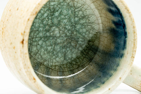 Close-up of the cup's interior showing the textured blue-green glaze pooling against the rim.