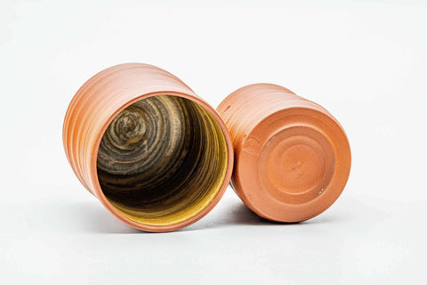 The pair with one cup tipped to show the yellow brushed interior.