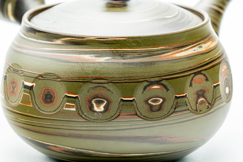 Close-up of the carved medallion band and the green-and-brown marbled nerikomi clay.