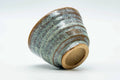 Teacup tilted to show the lower body and unglazed foot.