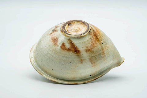 The katakuchi tipped on its side, showing the base and orange kiln blushing.