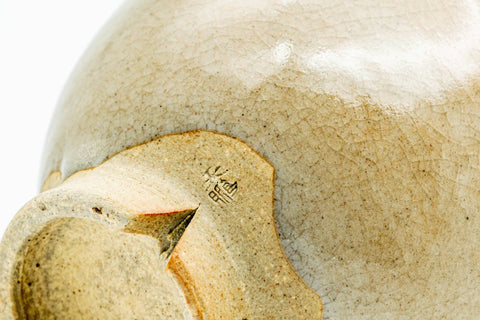 Close-up of the foot and lower body, showing the clay and glaze texture.