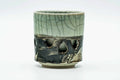 Side view of the teacup, showing the horse motif and crackle glaze.